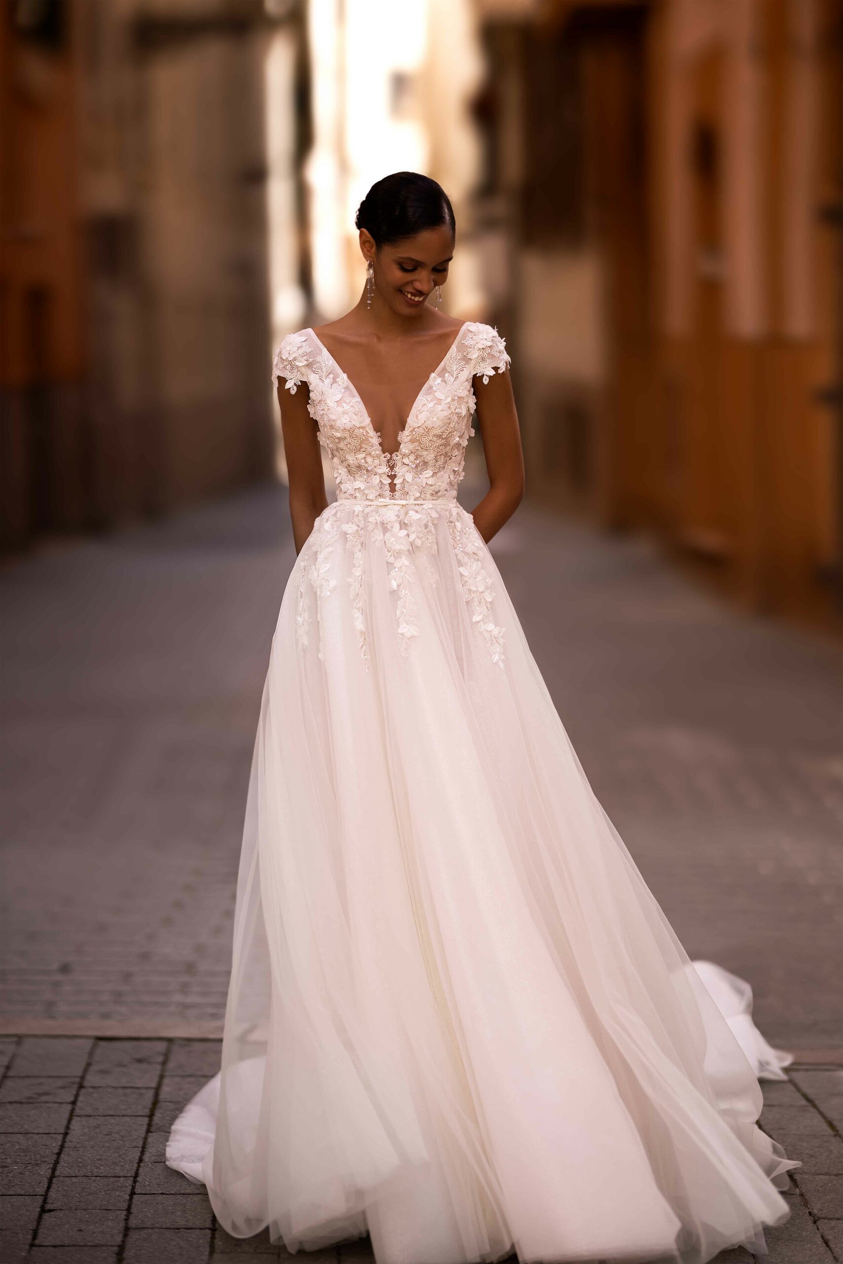 Abito da sposa Edwina Wonà con corpetto floreale tridimensionale, profondo scollo a V e ampia gonna in tulle leggero, disponibile presso Altomare Sposa a Modena.
