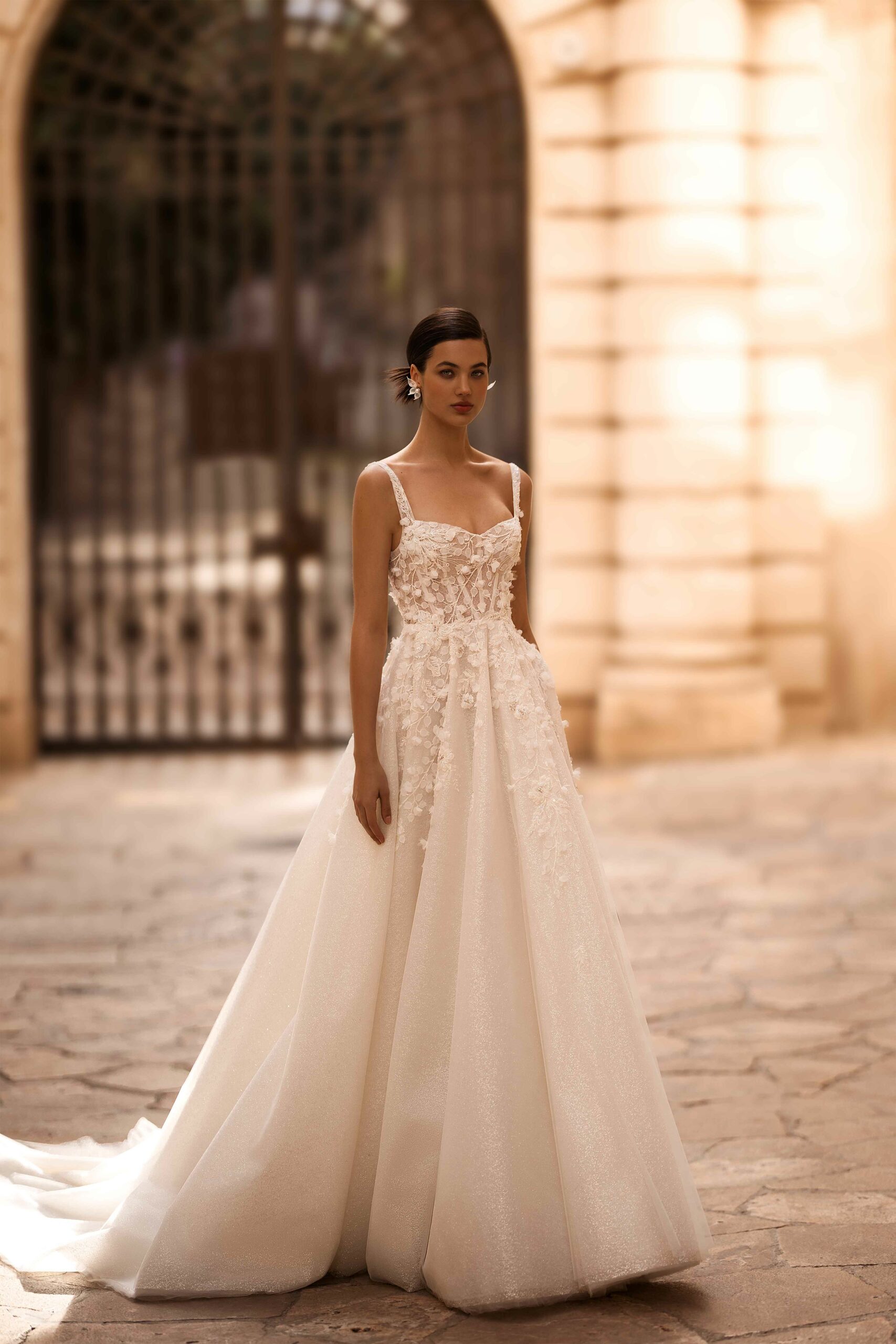 Abito da sposa Hazel Wonà con corpetto floreale 3D, spalline sottili e ampia gonna brillante in stile principesco, disponibile presso Altomare Sposa a Modena.