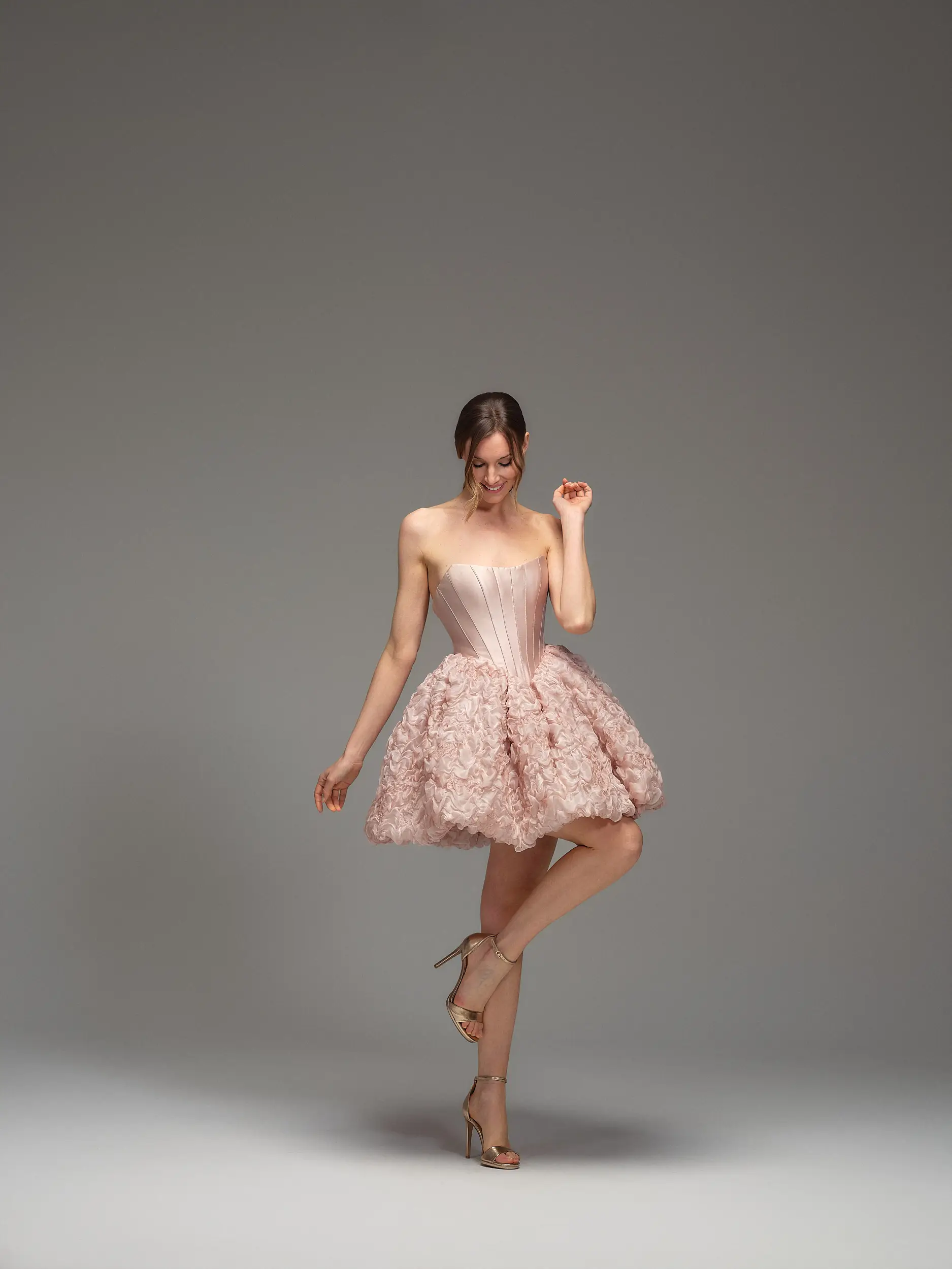 Abito Maria Pia Lara corto con bustier senza spalline e mini gonna cipria con fiori tridimensionali, disponibile da Altomare Sposa atelier a Modena.